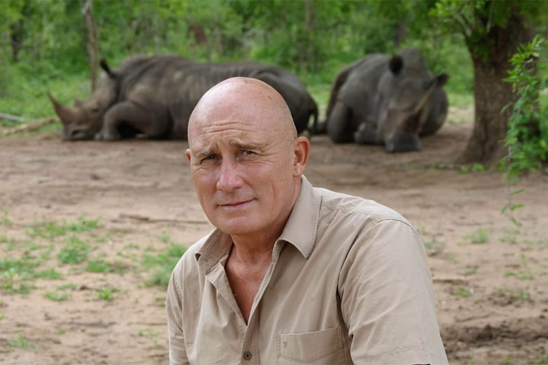 Patrick spécilaiste des safaris pose devant des rhinocéros